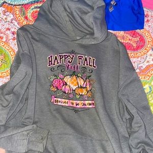 A large grey pullover with a fall design on the front